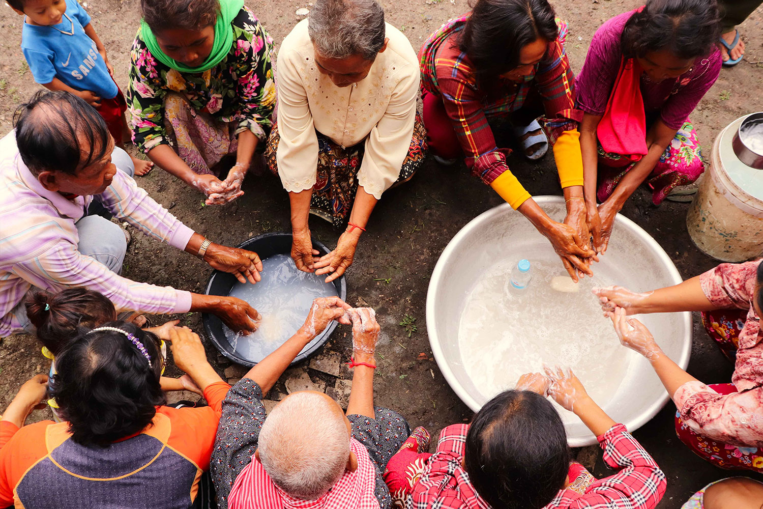 Menschen in Kambodscha, Battambang beim Händewaschen über Wassereimern