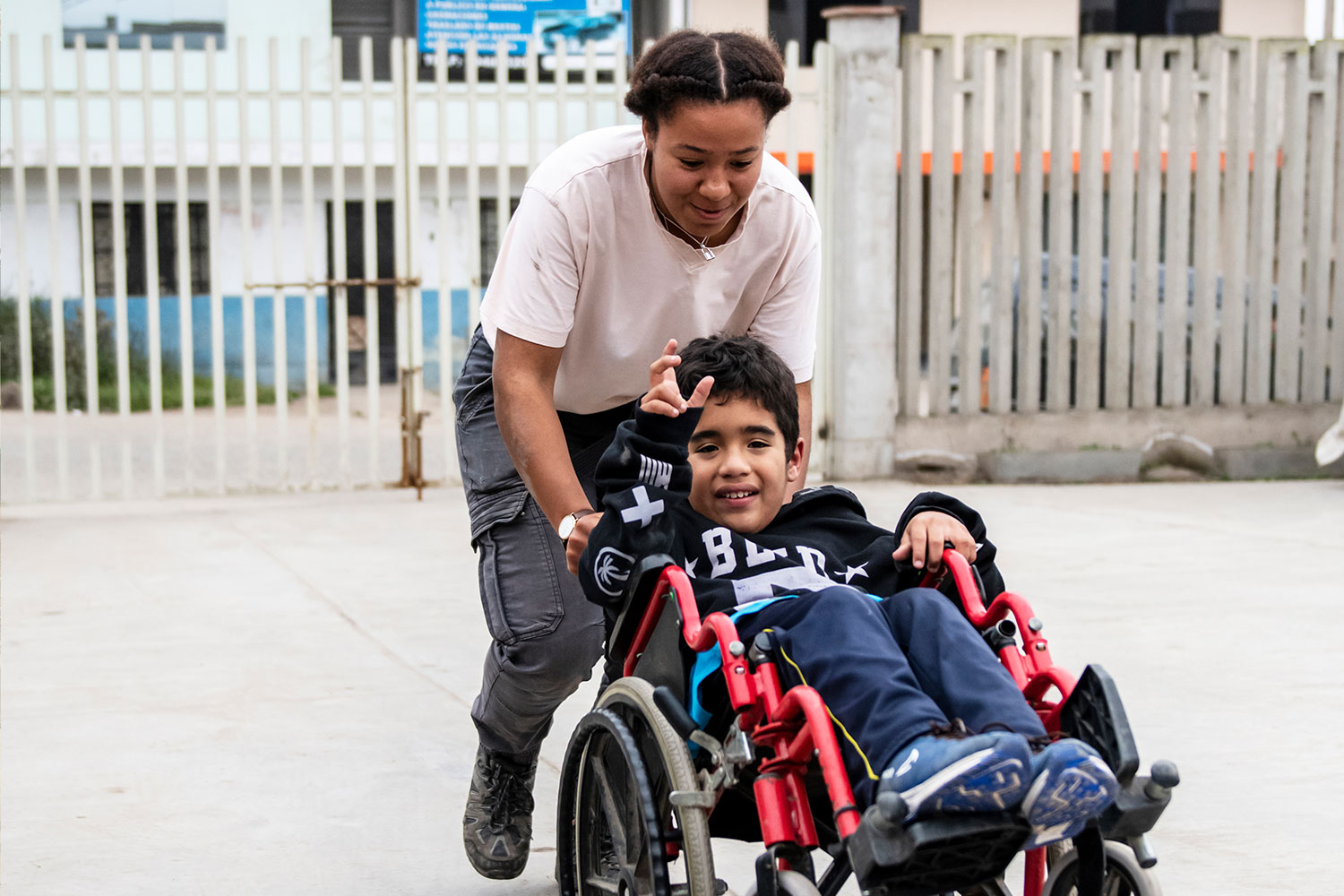 Freiwillige in Peru, Lima schiebt Jungen im Rollstuhl an