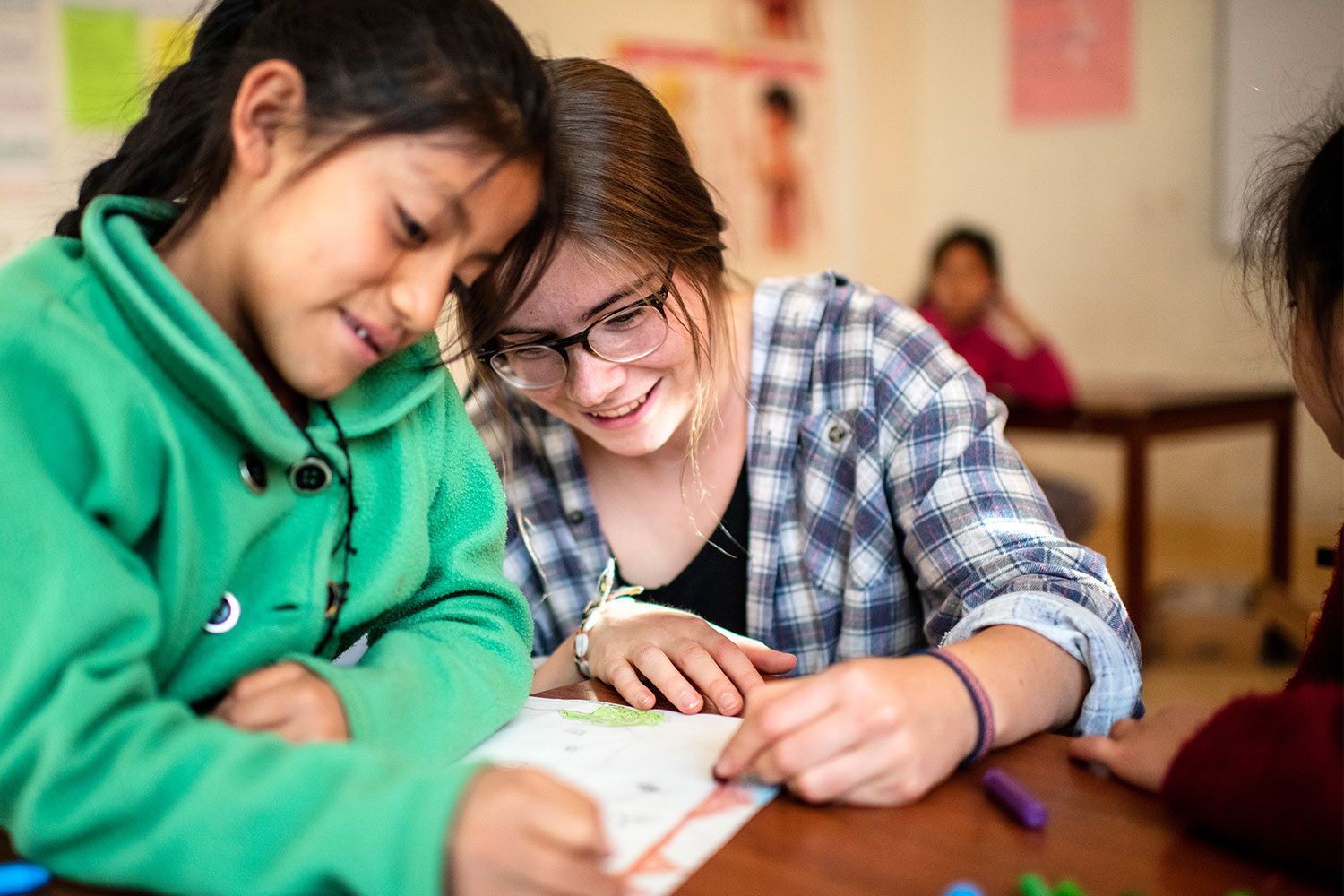 Freiwillige im Bildungszentrum „MICANTO“ hilft einem Mädchen bei den Hausaufgaben